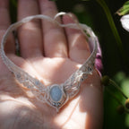 Bijou de cheville en micro macramé écru et aigue-marine posé sur une peau claire, bracelet mariage elfique et sirène. Coton et Astrance