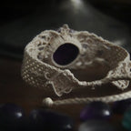 Bracelet large en macramé avec améthyste naturelle, bijou artisanal spirituel photographié dans un univers wicca gothique. Coton et Astrance