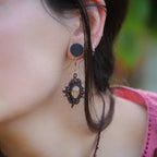 « Boucles d’oreilles elfiques losange en citrine dorée et grenat rouge, portées sur modèle à peau claire et cheveux bruns – Bijoux bohèmes artisanaux en micro macramé fait main en France »