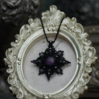 Bijou elfique sombre en micro macramé noir, pendentif étoile lumineux photographié sur fond gothique romantique. Coton et Astrance